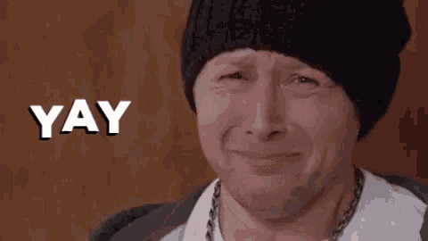 a man wearing a black hat is crying and the word yay is written above him .