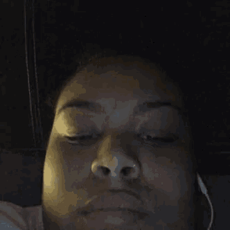 a close up of a woman 's face with her eyes closed and headphones on