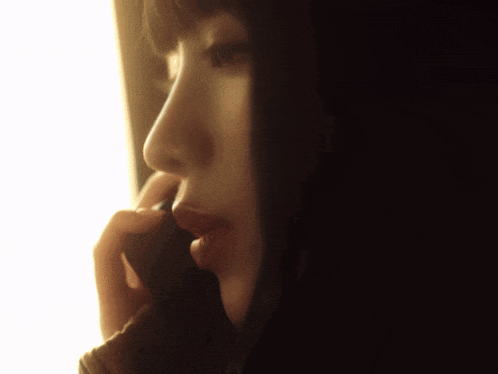 a close up of a woman 's face talking on a phone