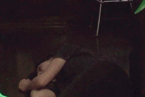 a woman is laying on the floor in a dark room with her head on her hands .