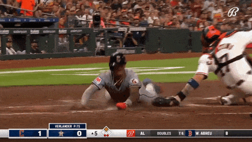 a baseball player is sliding into home plate during a game