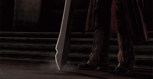 a man in a red coat is holding a large sword in his hands .