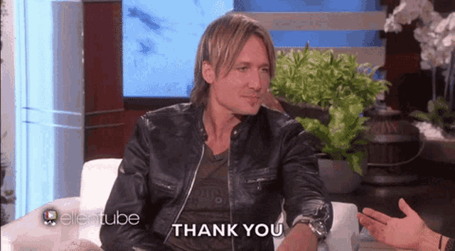 a man in a leather jacket says thank you during an interview