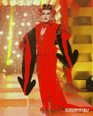 a drag queen in a red and black dress with xtecrystali written on the bottom right
