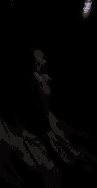 a person with a white mask on their face in the dark