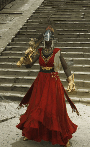 a woman in a red dress and gold gloves is holding a sword