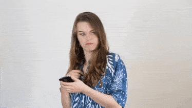 a woman in a blue shirt is dancing with her arms outstretched .