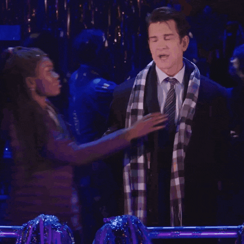 a man in a suit and tie is hugging a woman in a plaid scarf