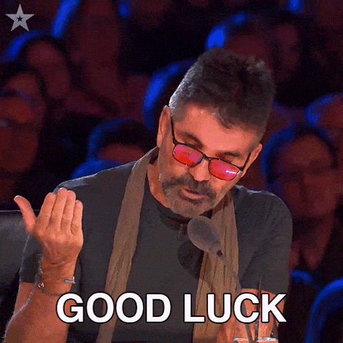 a man wearing glasses and a scarf says " good luck "