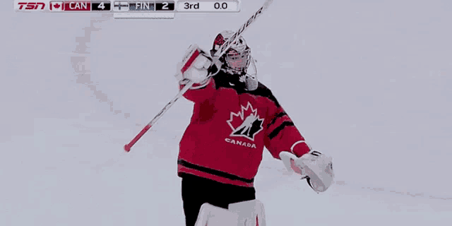 a hockey player wearing a red jersey that says canada on it