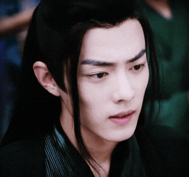 a close up of a young man 's face with long hair