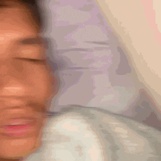 a blurry picture of a person laying on a bed with their eyes closed