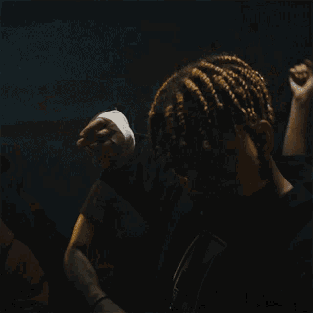 a close up of a person 's face with dreadlocks and a black jacket