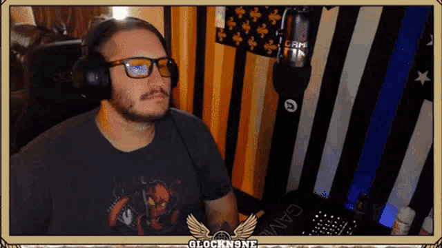 a man wearing glasses and headphones is sitting in front of a microphone with the words glockn9ne on the bottom