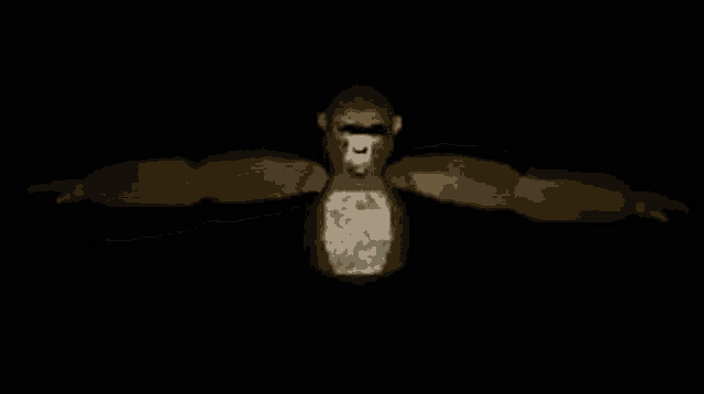 a statue of a gorilla with its arms outstretched in a dark room