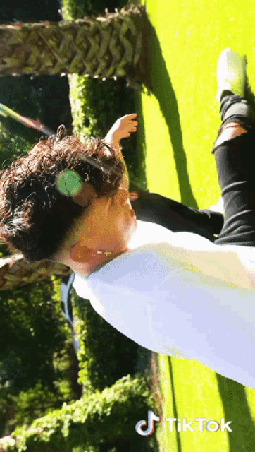 a man is laying on the grass with a tiktok logo on the bottom right