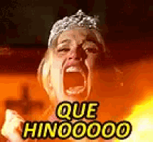 a woman with a crown on her head is screaming in front of a fire while wearing a tiara .