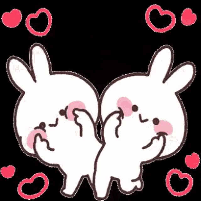 a couple of rabbits are standing next to each other with hearts around them .
