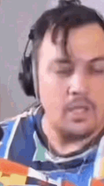 a man with a beard is wearing headphones and looking at something .