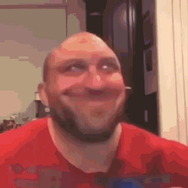 a bald man with a beard is making a funny face .
