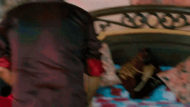 a person is laying on a bed with a book called harry potter on it .