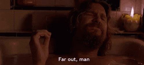a man with a beard is laying in a bathtub with his eyes closed .