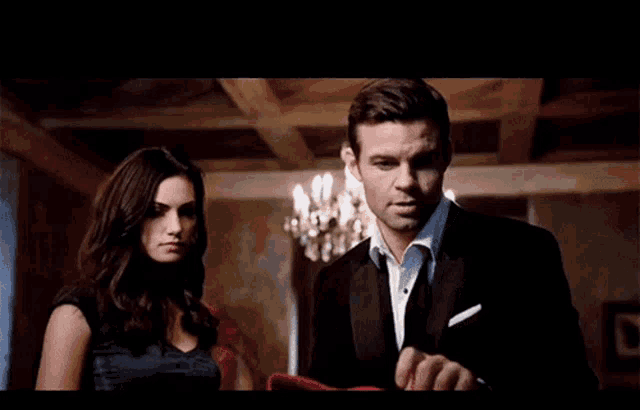 a man and a woman are standing next to each other in a dark room