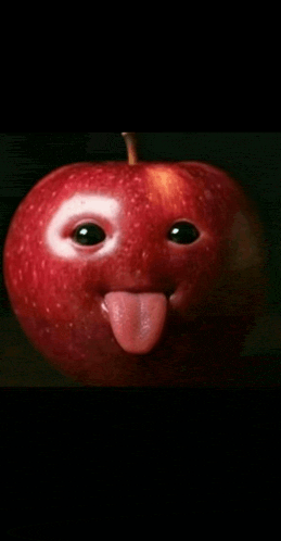 a red apple with a face carved into it sticking out its tongue
