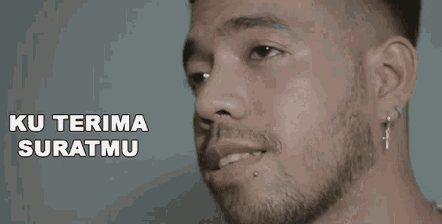 a close up of a man 's face with the words ku terima suratmu behind him