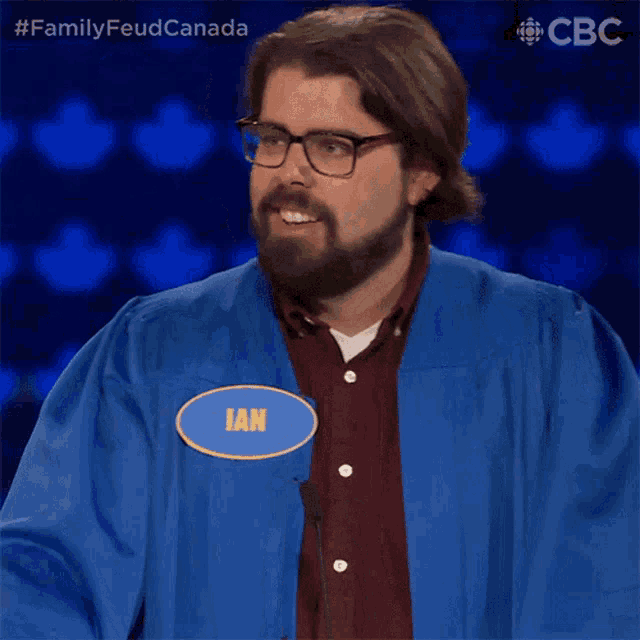 a man wearing glasses and a blue gown has a name tag that says ian