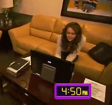 a woman sits on a couch in front of a computer and a clock that says 4:50 pm on it
