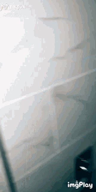 a person is standing in a bathroom with a bottle of soap on the floor .