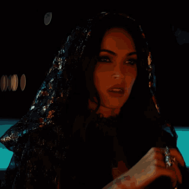 a woman with vampire teeth is wearing a cape