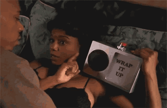 a woman is laying on a bed holding a box that says wrap it up