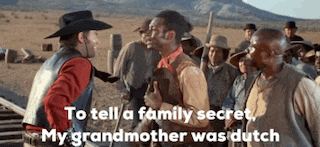a man in a cowboy hat is talking to another man in a crowd of men .