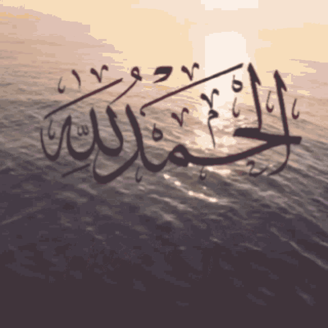 a sunset over the ocean with arabic writing on it