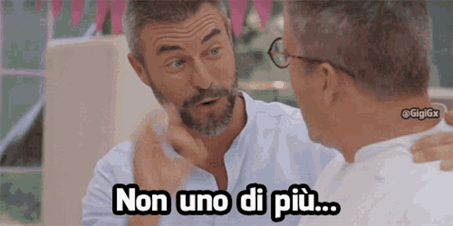 a man with a beard and glasses is talking to another man with the caption non uno di più