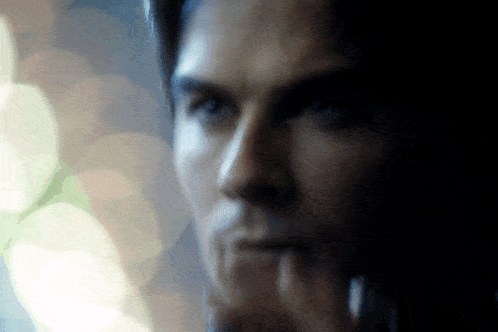 a close up of a man 's face with a blurry background behind him