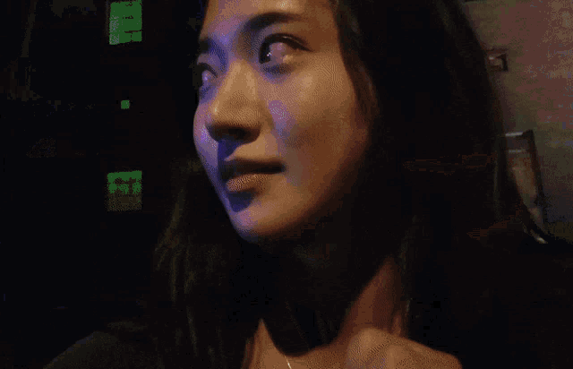 a woman stands in front of a blue sign that says a