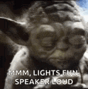 a close up of a statue of yoda with the words `` mmm , lights fun , speaker loud '' written on it .
