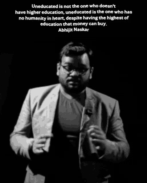 a man in a suit stands in front of a microphone with a quote from abhijit naskar