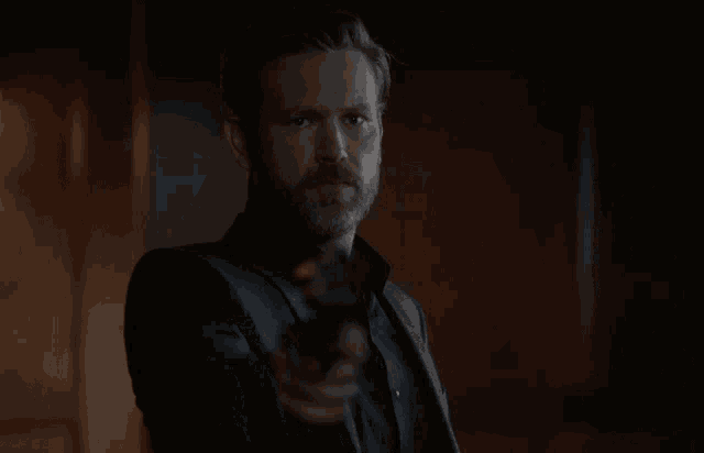 a man in a suit is pointing a gun
