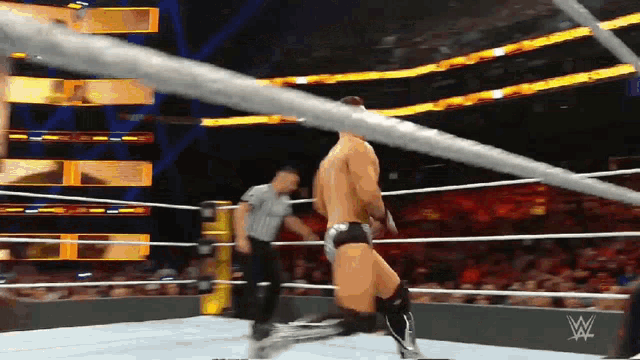 a man in a wrestling ring with a w logo on the wall