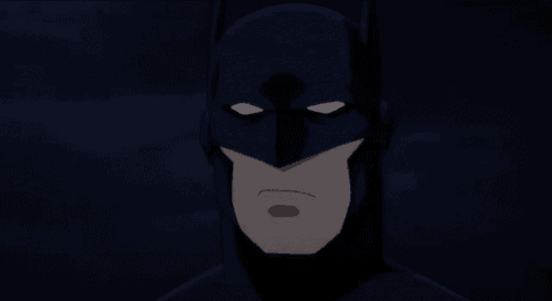 a close up of batman 's face with his mouth open and his eyes closed