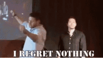 two men are standing next to each other on a stage and one of them says i regret nothing