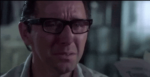 a man wearing glasses is crying with tears running down his face .