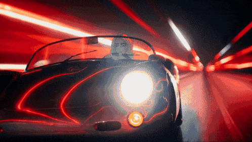 a man is driving a sports car in a tunnel at night