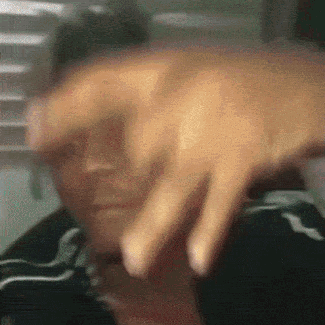a blurry picture of a person 's face with a hand covering it