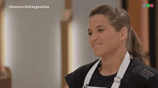 a woman wearing a black shirt and white apron is on a tv show called master chef argentina