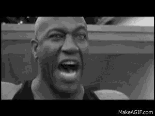 a black and white photo of a man screaming with his mouth wide open .